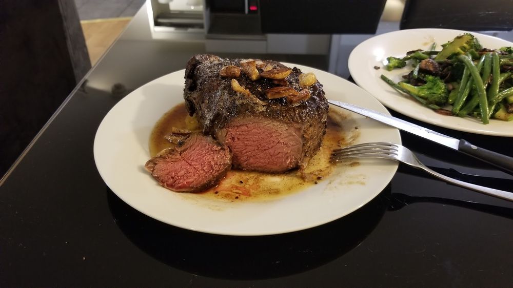 Roast beef carved into pink slices with a side of green beans